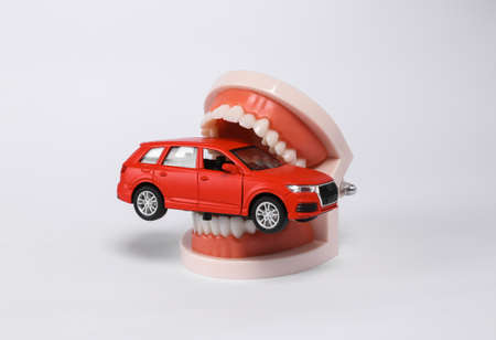Human jaw with car model isolated on white background