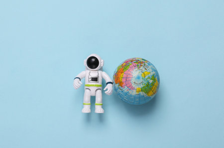 Astronaut toy model with globe on blue background. space missionの写真素材