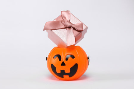 Halloween jack pumpkin bucket with gift box isolated on white background. Trick or Treatの写真素材