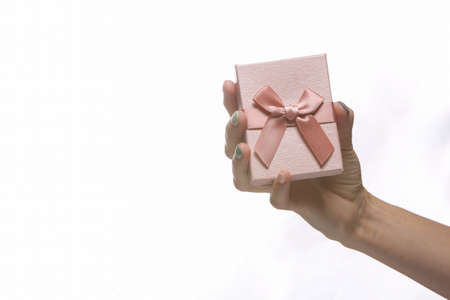 Female hand holding a gift box isolated on white backgroundの写真素材