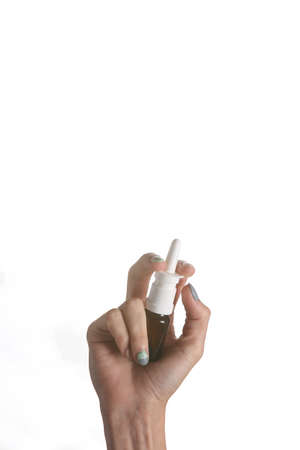 Nasal spray bottle in female hand isolated on white backgroundの写真素材