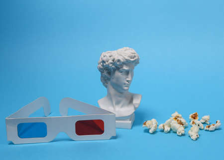 David bust with 3d glasses and popcorn on blue background. entertainment. Minimal still life. concept artの写真素材