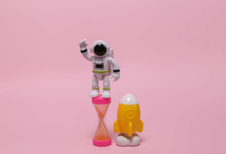 Space mission concept or startup. Space model shuttle with hourglass and astronaut on pink backgroundの写真素材