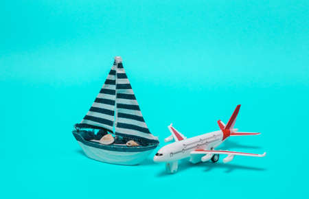 Travel, voyage concept. Model of passenger plane with sailboat on blue backgroundの写真素材