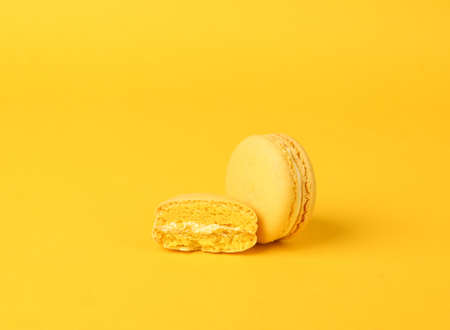 Yellow macaroon on yellow background. French sweet delicacy. color trendsの写真素材