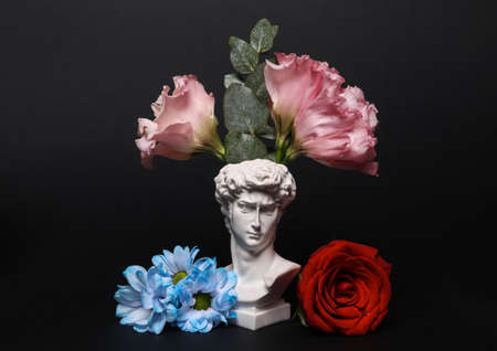 Romantic, valentine's day concept. David bust with flowers isolated on black backgroundの写真素材