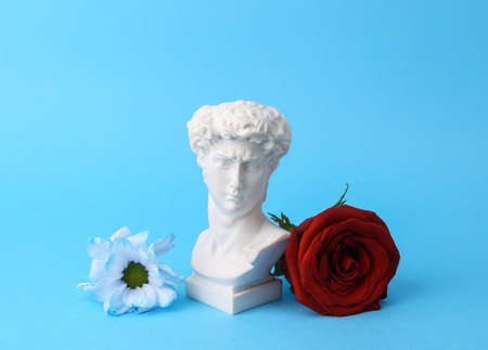 Romantic, valentine's day concept. David bust with flowers isolated on blue backgroundの写真素材