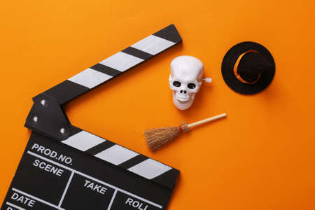 Horror movie, halloween concept. Movie clapperboard with halloween decor on orange backgroundの写真素材