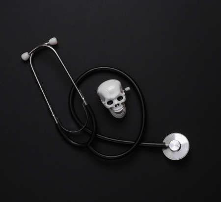 medical still life. Stethoscope with a skull on a black background. Deadly diseases. top viewの写真素材
