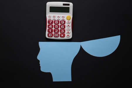 Open your mind, mental health concept, creative thinking. Paper silhouette of human head and calculator on black backgroundの写真素材