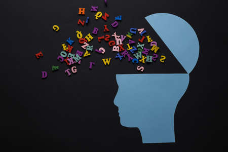 Open your mind, mental health concept, creative thinking. Paper silhouette of human head with letters on black backgroundの写真素材