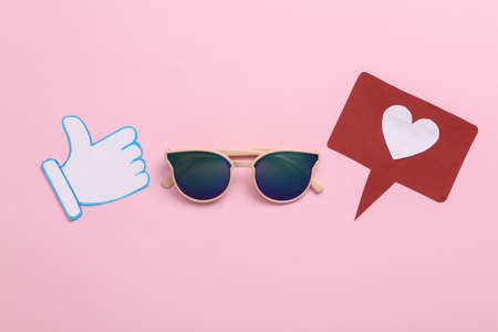 Sunglasses with thumbs up and like notification icons on pink background. travel concept. Rating,...