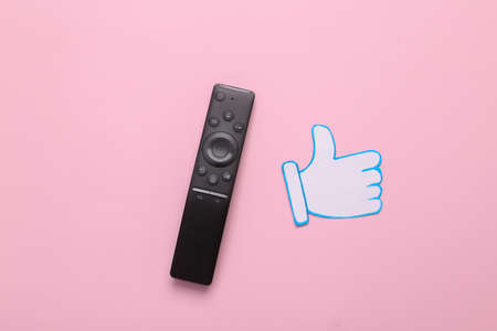 Tv remote with Paper cut Thumbs up notification icon on pink background. social media. Rating,...