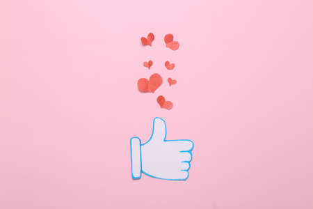 Paper cut Thumbs up notification icon with like hearts on pink background. social media. Rating,...