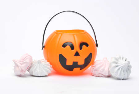 Jack lantern candy bucket with sweet meringue isolated on a white background. Happy Halloween