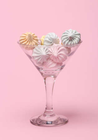 Cocktail martini glass with sweet meringue isolated on pink background.の写真素材