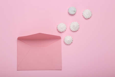Sweet meringue with envelope on pink background. Romantic, love concept, March 8 or mother's day. top view. flat layの写真素材