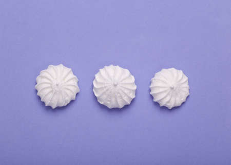 Sweet meringue on purple background. top view. flat layの写真素材