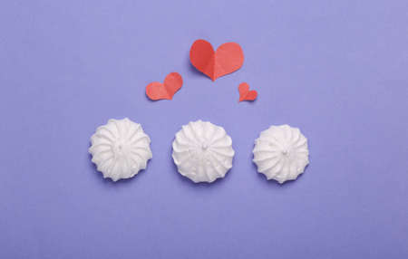 Sweet meringue with hearts on purple background. Romantic, love concept, March 8 or mother's day. top view. flat layの写真素材