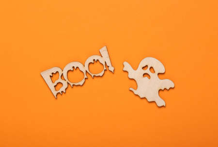 Happy halloween concept. Wood carved ghost and word boo! on orange background. Trick or treat. top viewの写真素材