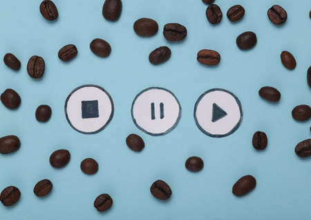 Coffee beans with icons start, stop, pause of media player on blue background. top viewの写真素材