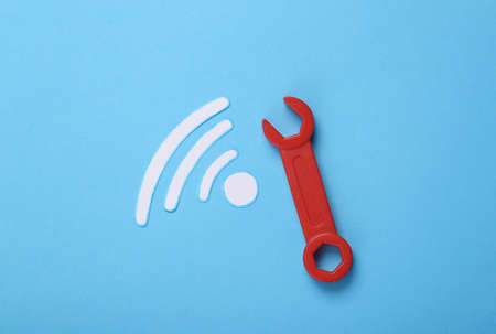 Wi-Fi connection repair concept. Wrench and waves wifi icon on blue background. top view