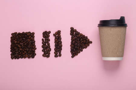 Coffee beans in the shape of start, stop, pause icons of media player and coffee cup on pink background. top viewの写真素材