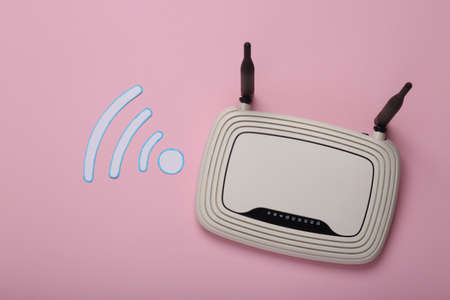 Paper cut Waves wi-fi icon and Wi-Fi router on pink background. top viewの写真素材