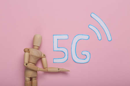Wooden puppet present 5g on pink background.の写真素材