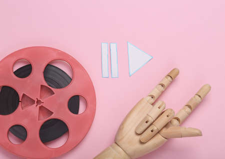 Wooden hand showing rock gesture with Magnetic Tape Bobbin and icons start, stop, pause of media...