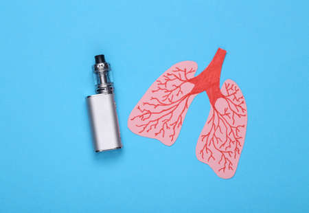 Harm of smoking for lung health concept. Paper lungs with vaping device on blue background