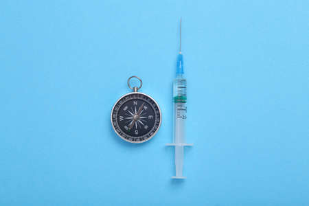 Syringe with a compass on a blue background. top viewの写真素材