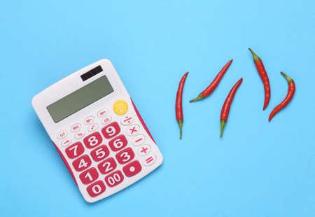 Chili pepper With a calculator on a blue background. pepper spiciness