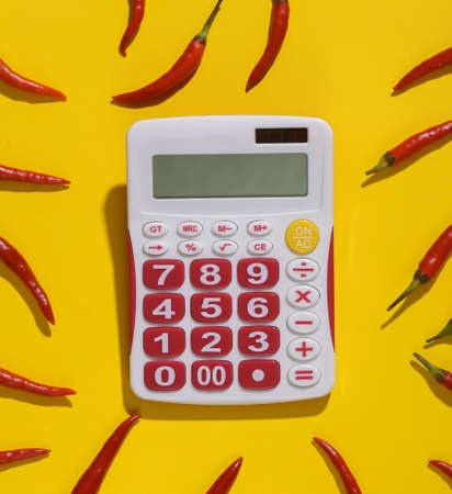 Chili pepper With a calculator on yellow background. pepper spicinessの写真素材