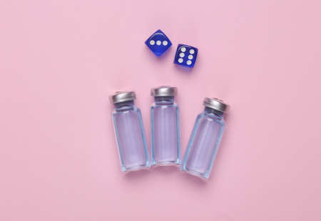 medical concept. Vaccine bottle with dice on pink backgroundの写真素材