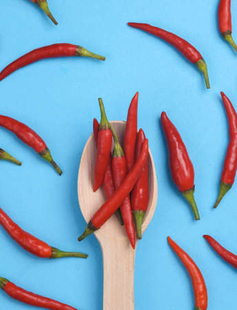Wooden spoon with red chili pepper on blue backgroundの写真素材