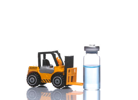 Toy forklift model with vaccine bottle isolated on white background with reflectionの写真素材