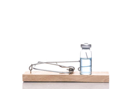 Mousetrap with vaccine bottle isolated on white background with reflectionの写真素材