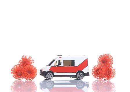 Miniature ambulance with virus molecules isolated on white background with reflection
