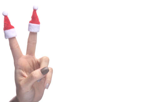 Hand fingers with two santa caps isolated on white background. christmas conceptの写真素材