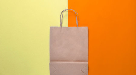 Empty paper shopping bag on a yellow blue pastel background. Trend of minimalism. top view.の写真素材