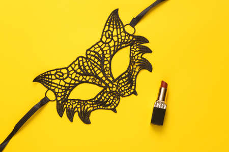 Love, romantic, sexy concept. Lacy sexy cat mask with lipstick on a yellow background. top viewの写真素材