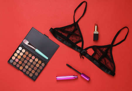 Lace bra with a set of cosmetics on a red background. romantic date conceptの写真素材