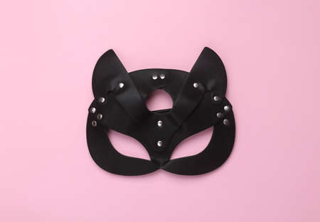 Leather bdsm cat mask on pink background. Top view. Sexual role playing. Flat layの写真素材