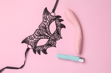 Sex games. Sexy lace mask with vibrators on a pink background. flat layの写真素材