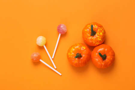 Trick or treat. Pumpkins with lollipops on orange background. Halloween conceptの写真素材