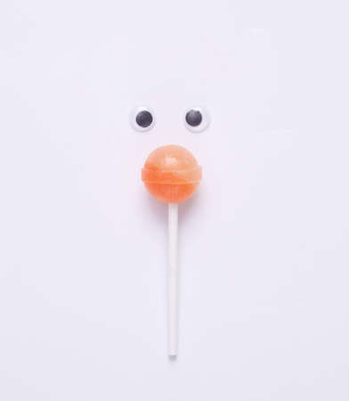 Minimal food concept. Lollipop with eyes on a white backgroundの写真素材