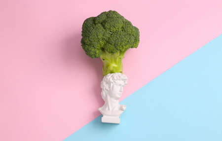 Healthy food concept. David bust with broccoli on pink blue background. Top viewの写真素材