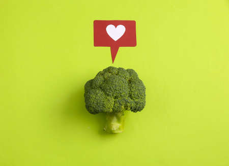 Broccoli with like icon on pink background. Healthy food concept. Food blog. Feedback, reaction, rating, social activity conceptの写真素材