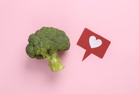 Broccoli with like icon on pink background. Healthy food conceptの写真素材